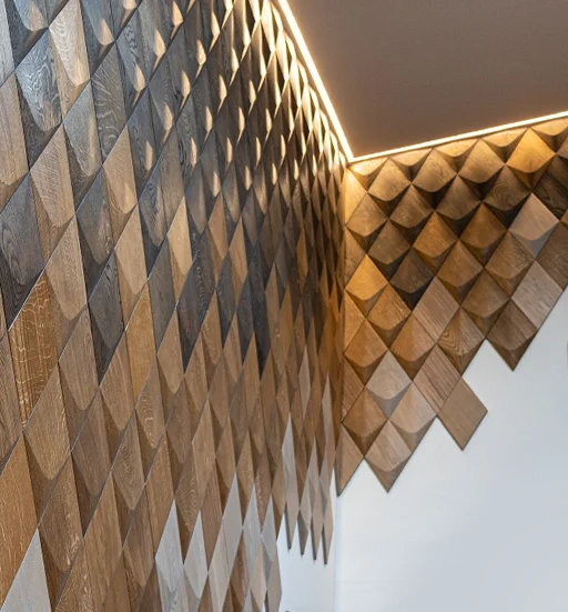 Modern wall installation made of 3D oak diamond-shaped panels with linear LED lighting along the ceiling.