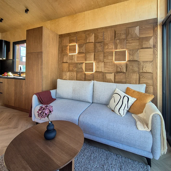 Oak wood wall paneling used as decorative accent wall behind modern sofa